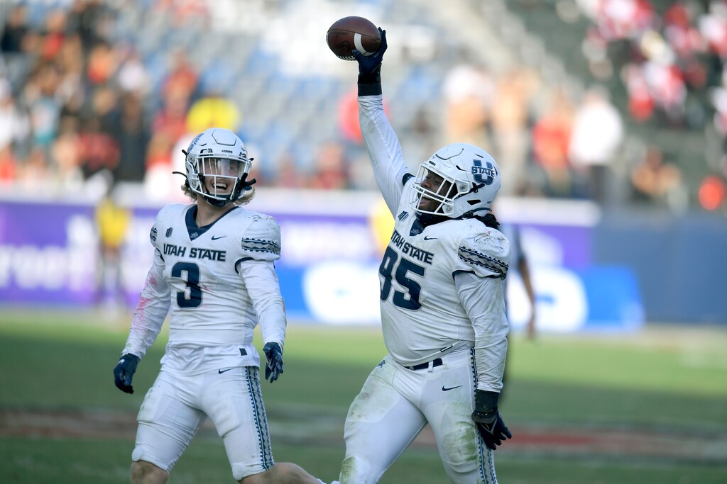 (John McCoy | AP) Utah State linebacker Justin Rice (3) looks at defensive tackle Marcus Moore (95) who recovered a fumble by San Diego State in the second half during an NCAA college football game for the Mountain West Conference Championship, Saturday in Carson, Calif.
