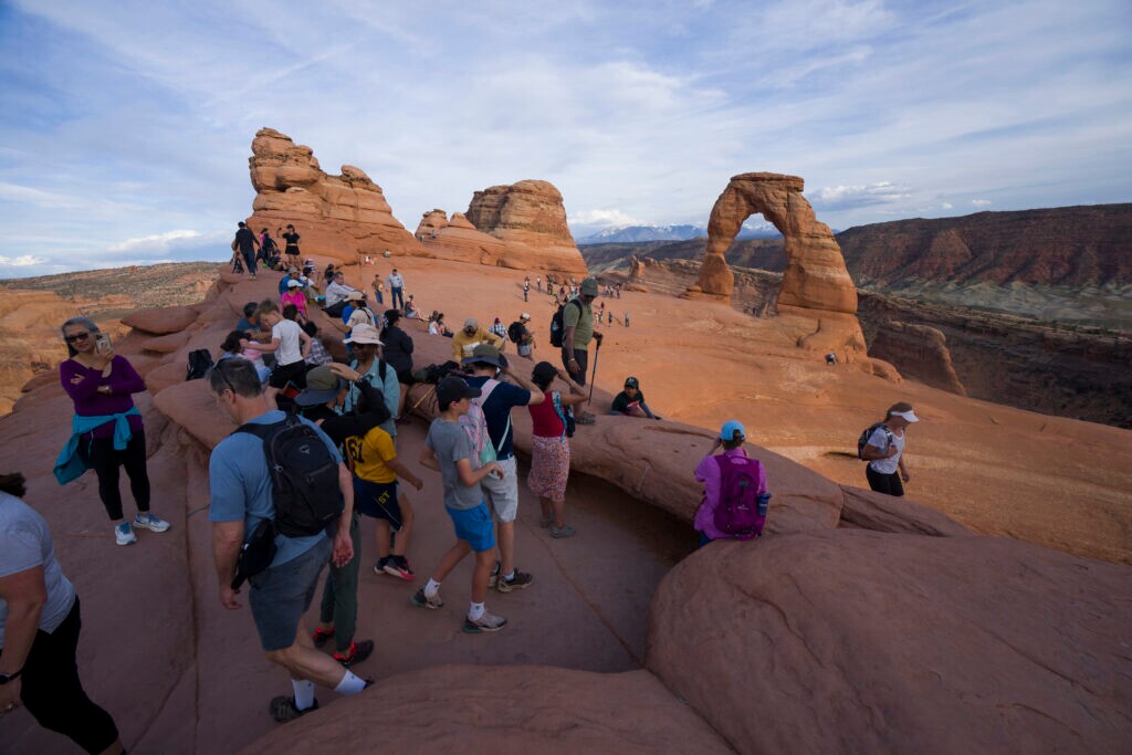 (Bethany Baker | The Salt Lake Tribune) People gather at Delicate Arch inside Arches National Park near Moab on Thursday, April 9, 2026.