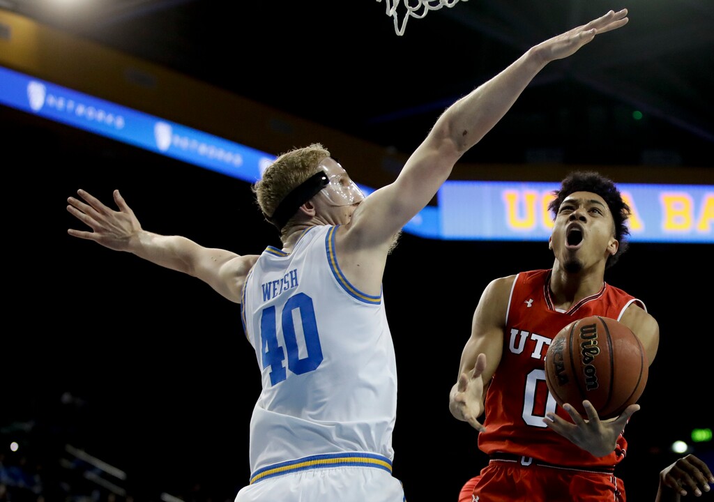 Utah guard Sedrick Barefield, right, shoots around UCLA center Thomas Welsh during the first half of an NCAA college basketball game in Los Angeles, Thursday, Jan. 11, 2018. (AP Photo/Chris Carlson)