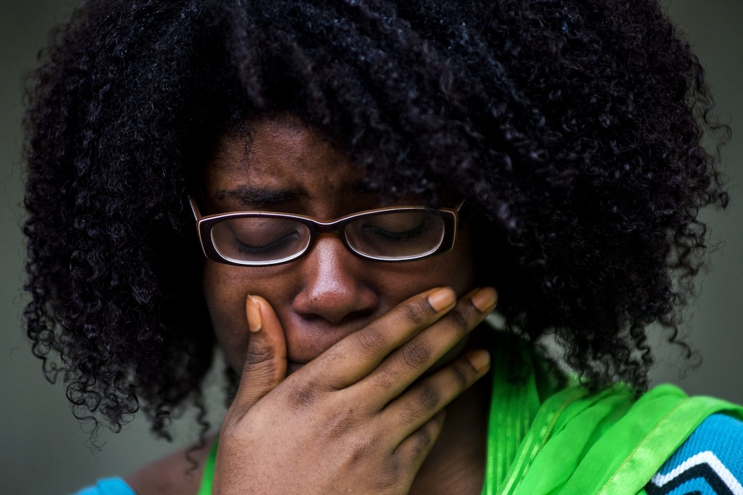 Alyssia Washington, 24, of Flint, Mich., gasps aloud as she tries to hold back tears while names of identified victims from the Las Vegas mass shooting are read aloud, while standing in a circle of more than 50 University of Michigan-Flint students and faculty members during a vigil at the McKinnon Plaza on campus Wednesday, Oct. 4, 2017 in downtown Flint. (Jake May/The Flint Journal-MLive.com via AP)