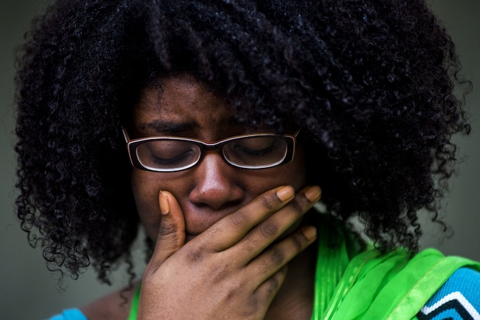 Alyssia Washington, 24, of Flint, Mich., gasps aloud as she tries to hold back tears while names of identified victims from the Las Vegas mass shooting are read aloud, while standing in a circle of more than 50 University of Michigan-Flint students and faculty members during a vigil at the McKinnon Plaza on campus Wednesday, Oct. 4, 2017 in downtown Flint. (Jake May/The Flint Journal-MLive.com via AP)