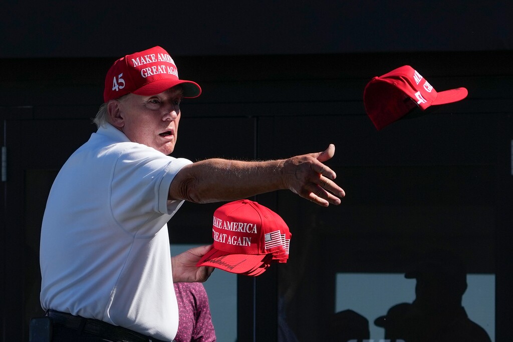 Former President Donald Trump throws autographed caps to the crowd during the final round of the Bedminster Invitational LIV Golf tournament in Bedminster, N.J., Sunday, Aug. 13, 2023. (AP Photo/Seth Wenig)