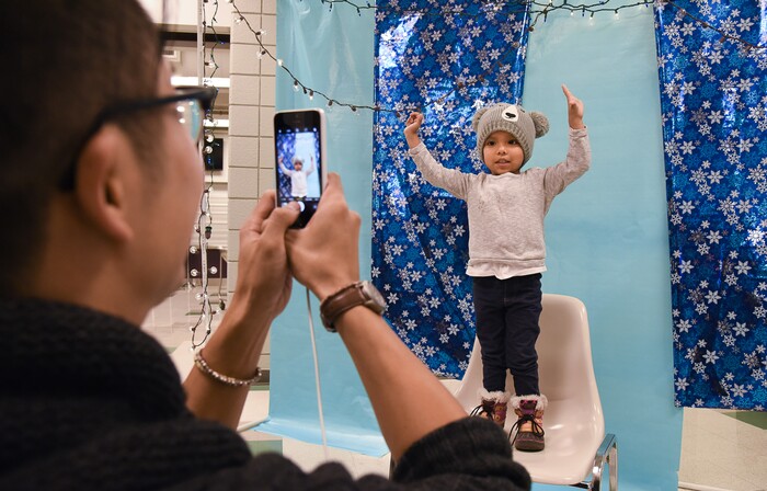 (Francisco Kjolseth  |  The Salt Lake Tribune)  Roselyn Garcia, 2, strikes a pose as Jess Ung with the Division of Youth and Family Services snaps a photo. Families could decorate a frame to hold their print. as part of Salt Lake City's Winter De-Stressor Festival at the Horizonte Instruction and Training Center in Salt Lake on Saturday, Dec. 15, 2018. .