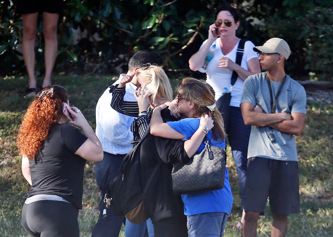 Anxious family members wait for news of students as two people embrace, Wednesday, Feb. 14, 2018, in Parkland, Fla. A shooting at Marjory Stoneman Douglas High School sent students rushing into the streets as SWAT team members swarmed in and locked down the building. (AP Photo/Wilfredo Lee)
