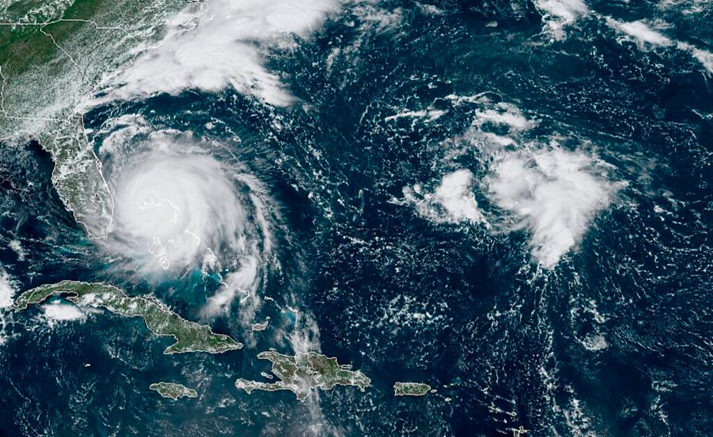 (NOAA | AP) This GOES-16 satellite image taken Monday, Sept. 2, 2019, at 16:40 UTC and provided by National Oceanic and Atmospheric Administration (NOAA), shows Hurricane Dorian, left, churning over Bahamas. Officials say the hurricane has killed at least five people.