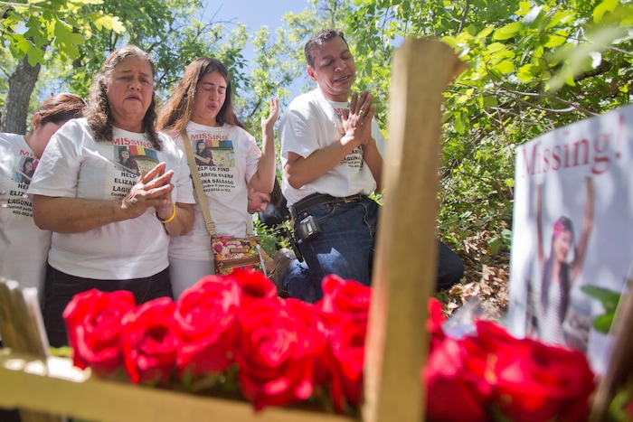 Family members, from left, Libertad Edith Salgado-Figueroa, Ruth Yolanda Laguna-Salgado, and Rosemberg Salgado, pray Friday, June 15, 2018, in Hobble Creek Canyon near Provo, Utah, where Elizabeth Elena Laguna-Salgado was found. The remains of the 26-year-old Mexican woman were discovered by a passer-by looking for a camping spot last month. She had been missing since April 16, 2015, when she was last seen walking home from her English language class. (Evan Cobb/The Daily Herald via AP)
