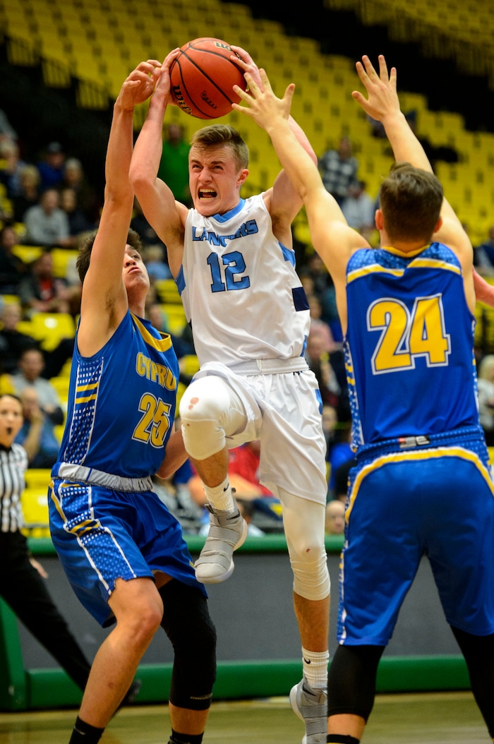 (Steve Griffin  |  The Salt Lake Tribune) Layton's Truman Brown splits the Cyprus defense of Tayven Aloi and Skyler Case during 6A basketball playoff game at the Utah Valley UniversityÕs UCCU Center in Provo Tuesday Feb. 27, 2018.