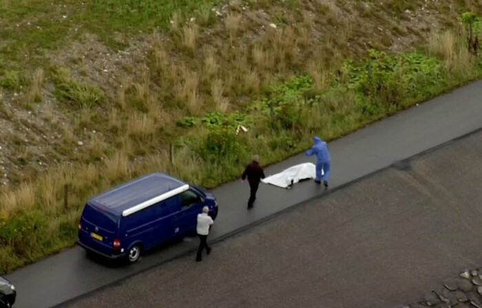 In this image taken from video on Monday Aug. 21, 2017, shows police forensic investigators as they prepare to move a  headless body of a woman that was found near Amager Denmark in the Baltic Sea  where a missing Swedish journalist is believed to have died on a privately built submarine earlier this month .  The headless torso found on a beach near Amager has been identified as that of missing Swedish journalist Kim Wall, Danish police said Wednesday Aug. 23, 2017. (TV2 via AP)