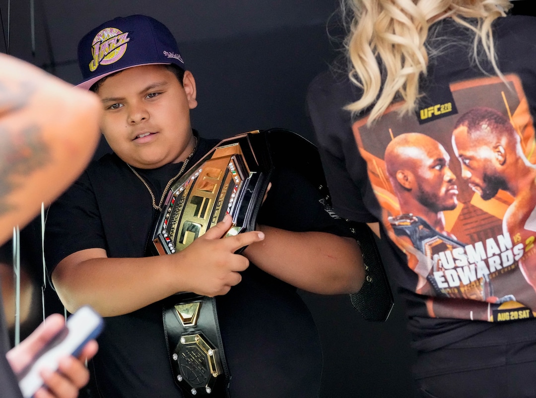 (Francisco Kjolseth | The Salt Lake Tribune) Fernando Medina, 10, of Orem gets a chance to have his picture taken with a UFC belt before the start of the mixed martial arts event featuring Nigerian UFC fighter Kamaru Usman, and Leon Edwards, of Jamaica at the top of the ticket at Vivint Arena in Salt Lake City on Saturday, Aug. 20, 2022. 