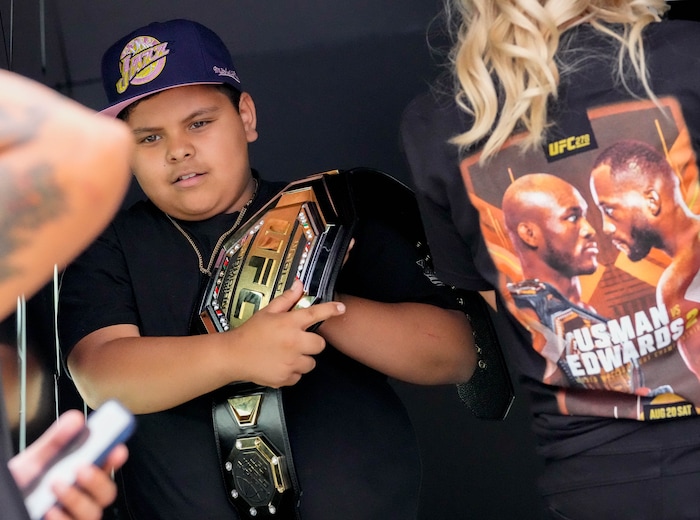 (Francisco Kjolseth | The Salt Lake Tribune) Fernando Medina, 10, of Orem gets a chance to have his picture taken with a UFC belt before the start of the mixed martial arts event featuring Nigerian UFC fighter Kamaru Usman, and Leon Edwards, of Jamaica at the top of the ticket at Vivint Arena in Salt Lake City on Saturday, Aug. 20, 2022. 
