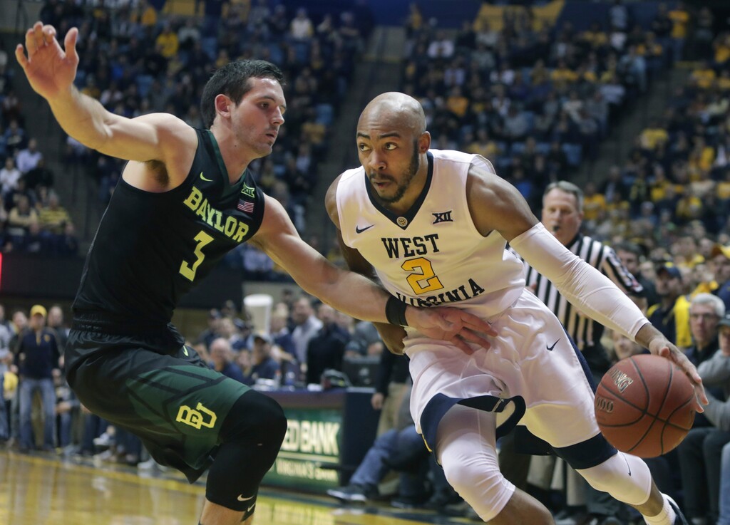 West Virginia guard Jevon Carter (2) drives to the basket while being defended by Baylor guard Jake Lindsey (3) during the second half of an NCAA college basketball game Tuesday, Jan. 9, 2018, in Morgantown, W.Va. (AP Photo/Raymond Thompson)