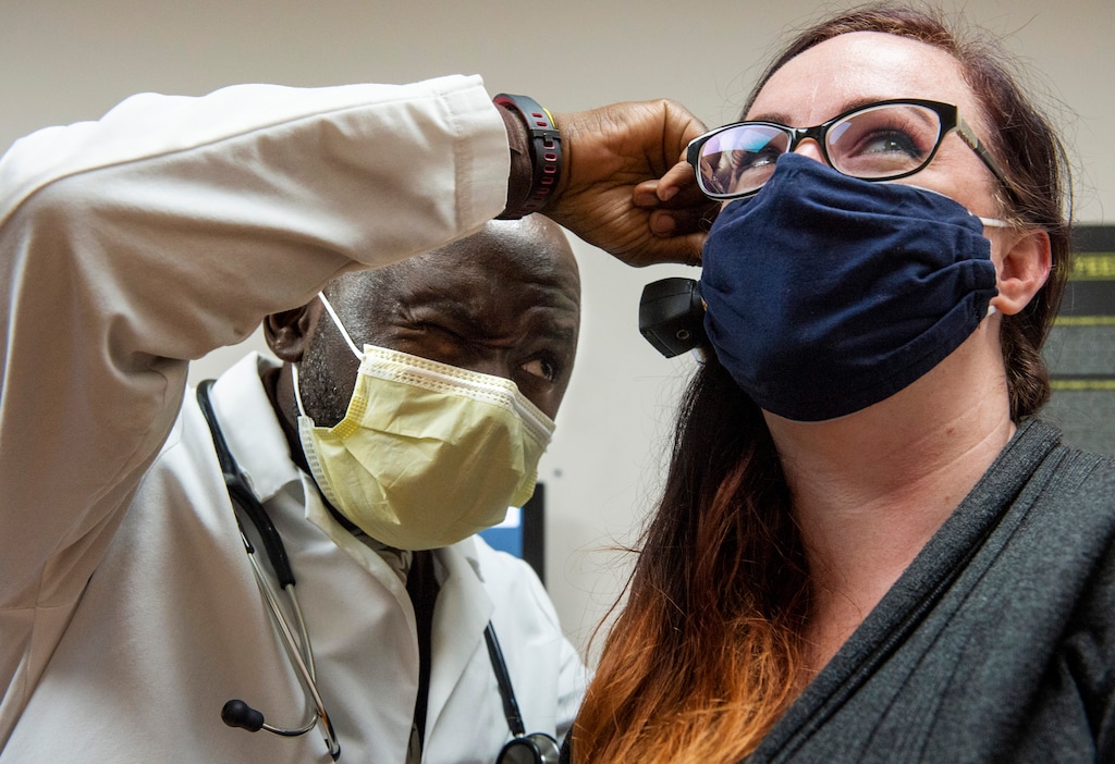 (Rick Egan  |  The Salt Lake Tribune)     Olivier Mulyangote PA, checks out Jessica, at the Health Clinics of Utah clinic on 1950 West, on Thursday, July 30, 2020.