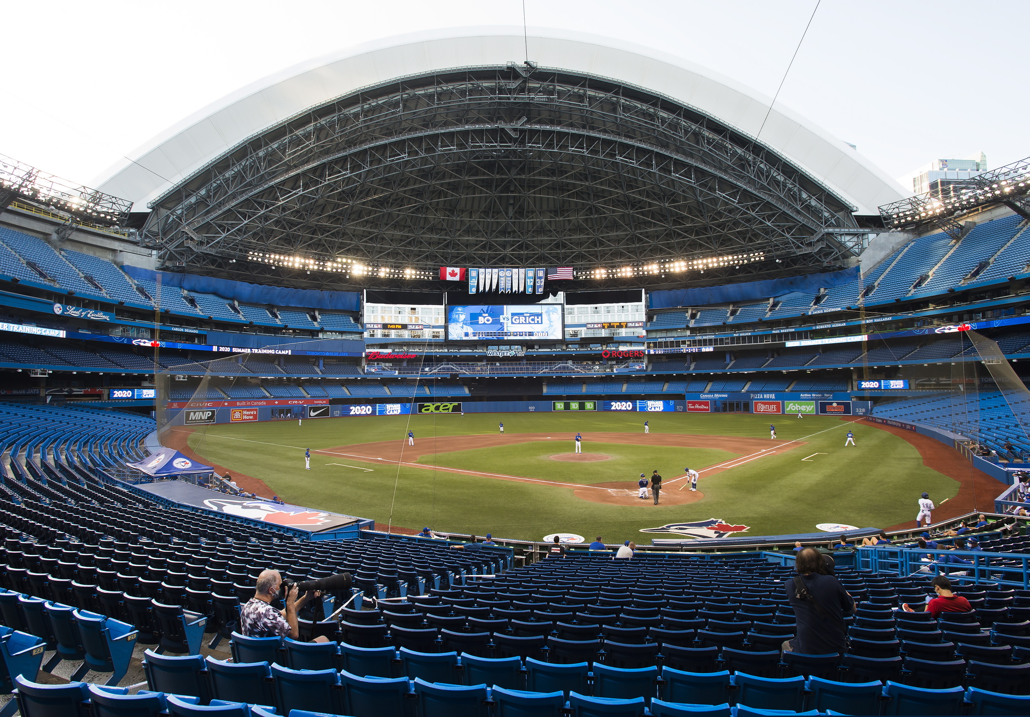 Photographers cover the game in an empty stadium during fourth-inning baseball game action in Toronto, Friday, July 17, 2020. (Nathan Denette/The Canadian Press via AP)