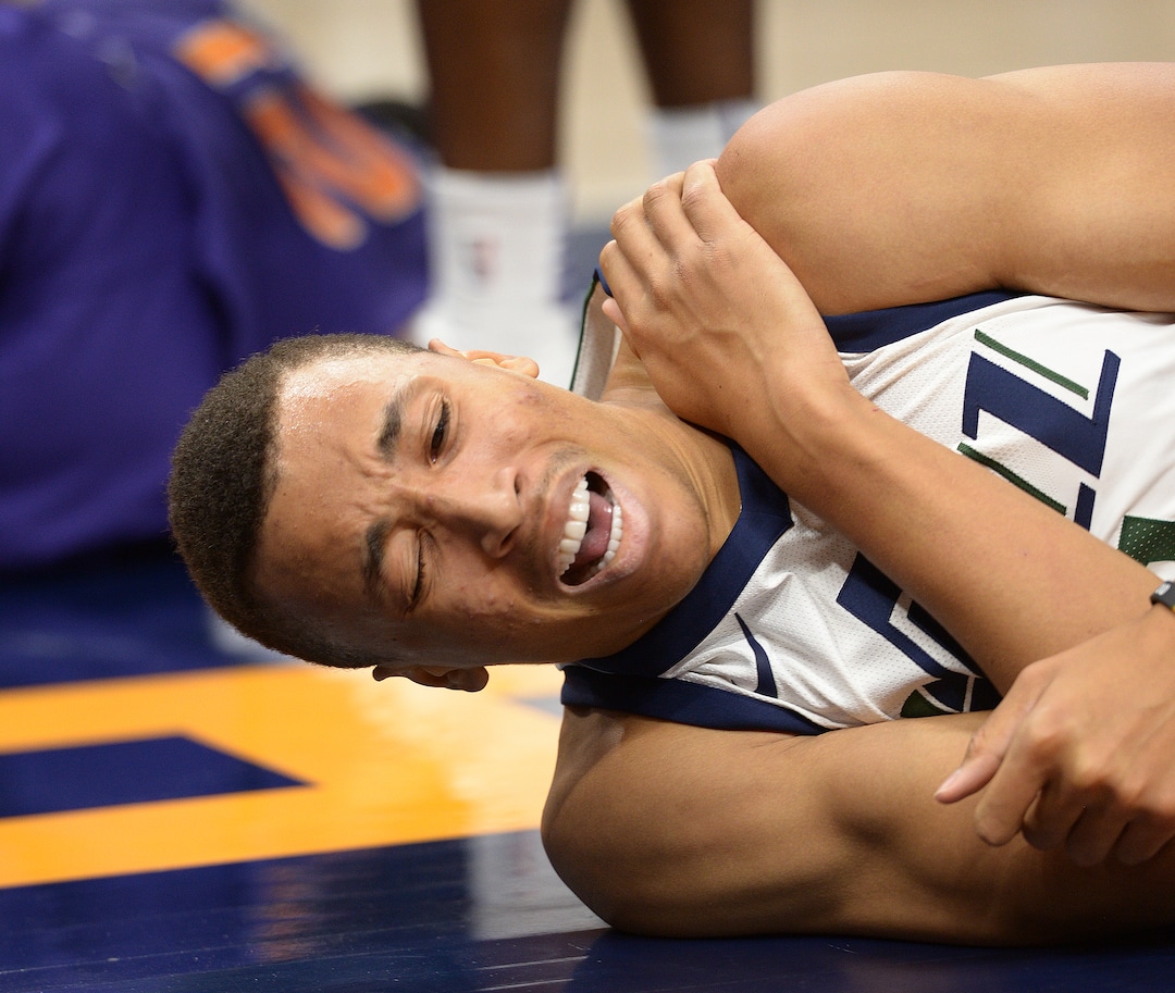 (Leah Hogsten  |  The Salt Lake Tribune) Utah Jazz guard Dante Exum (11) grimaces as he grabs his left shoulder after hitting the deck under the net as the Utah Jazz host the Phoenix Suns during preseason NBA basketball at Vivint Smart Home Arena in Salt Lake City, October 6, 2017.