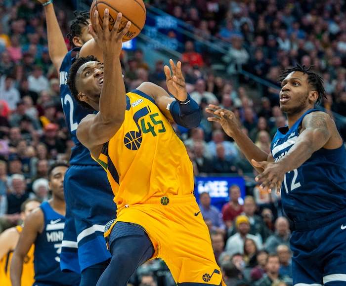 (Rick Egan  |  The Salt Lake Tribune)     Utah Jazz guard Donovan Mitchell (45) tries to take a shot under the basket, as he is guarded by Minnesota Timberwolves center Karl-Anthony Towns (32), and Minnesota Timberwolves guard Treveon Graham (12) and , in NBA action between the Utah Jazz and the Minnesota Timberwolves in Salt Lake City, Monday, Nov. 18, 2019.