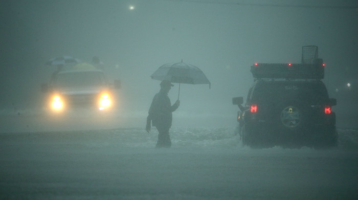 (Charlie Riedel | The Associated Press) A man walks through floodwaters from Tropical Storm Harvey as he evacuates his home on Sunday, Aug. 27, 2017, in Houston, Texas.
