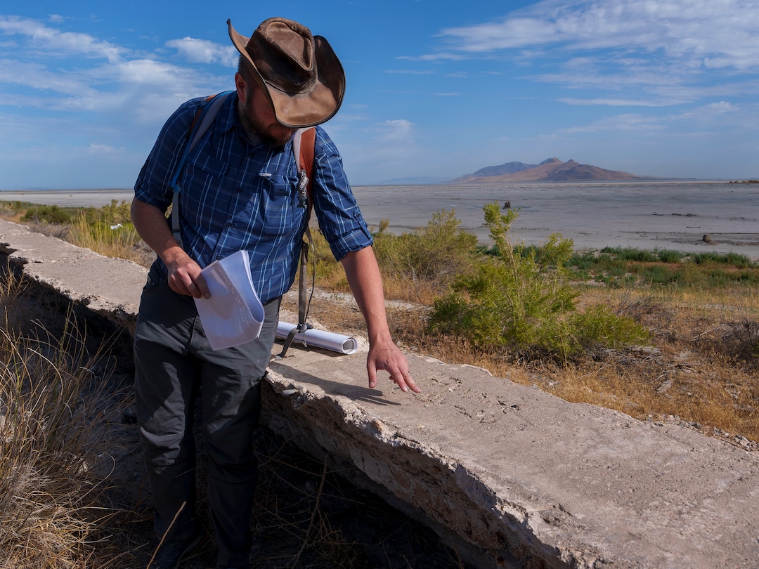 (Leah Hogsten | The Salt Lake Tribune) Christopher Merritt, a state historic preservation officer, points to graffiti, Thursday, July 21, 2022, that was written into the curing concrete of the Saltair sea wall in 1924 that reads "H. White  6/14/24." White was most likely a worker at Saltair at that time. The seawall was built to keep the salty water of the Great Salt Lake from compromising the train line that serviced the resort.