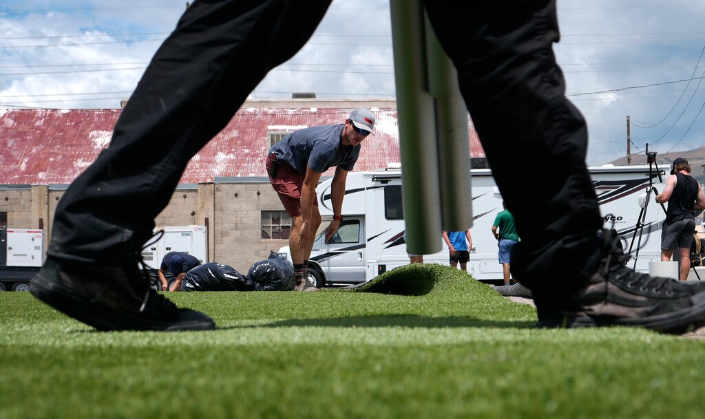 (Leah Hogsten | The Salt Lake Tribune) Corbin Mitchell with Backyard Greens rolls out turf grass at the Granary Live venue in Salt Lake City's Granary District, Wednesday, June 14, 2023.