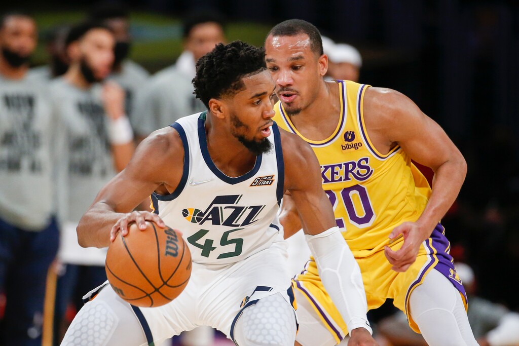 Utah Jazz guard Donovan Mitchell (45) is defended by Los Angeles Lakers guard Avery Bradley (20) during the second half of an NBA basketball game in Los Angeles, Monday, Jan. 17, 2022. The Lakers won 101-95. (AP Photo/Ringo H.W. Chiu)