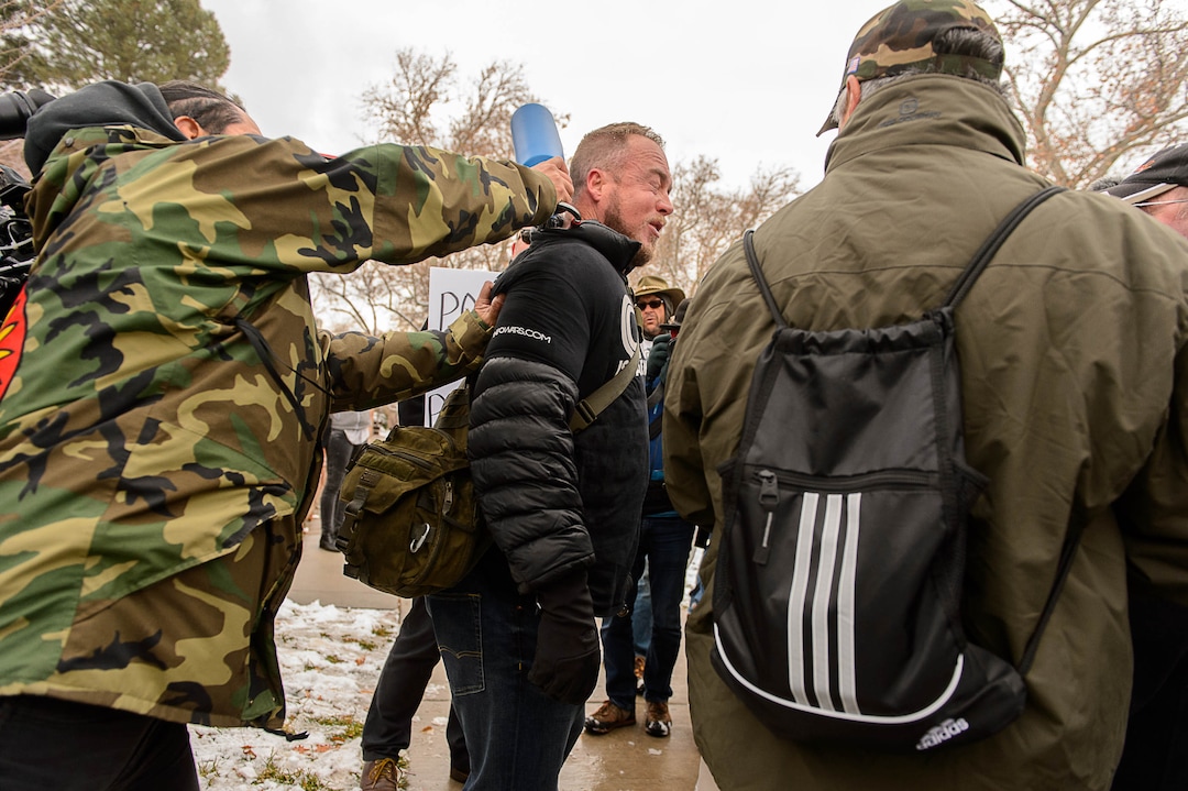 (Trent Nelson | The Salt Lake Tribune)  A man is hit in the head by a protester during an altercation at a rally protesting a visit by President Donald Trump, Monday December 4, 2017.