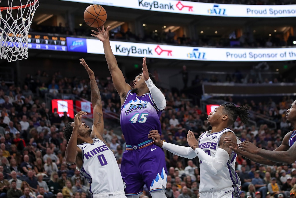 Utah Jazz guard Donovan Mitchell (45) shoots the ball between Sacramento Kings forward Trevor Ariza (0) and Sacramento Kings forward Richaun Holmes (22) during the second half of an NBA basketball game, Saturday, Oct. 26, 2019, in Salt Lake City. Utah Jazz won 113-81. (AP Photo/Chris Nicoll)