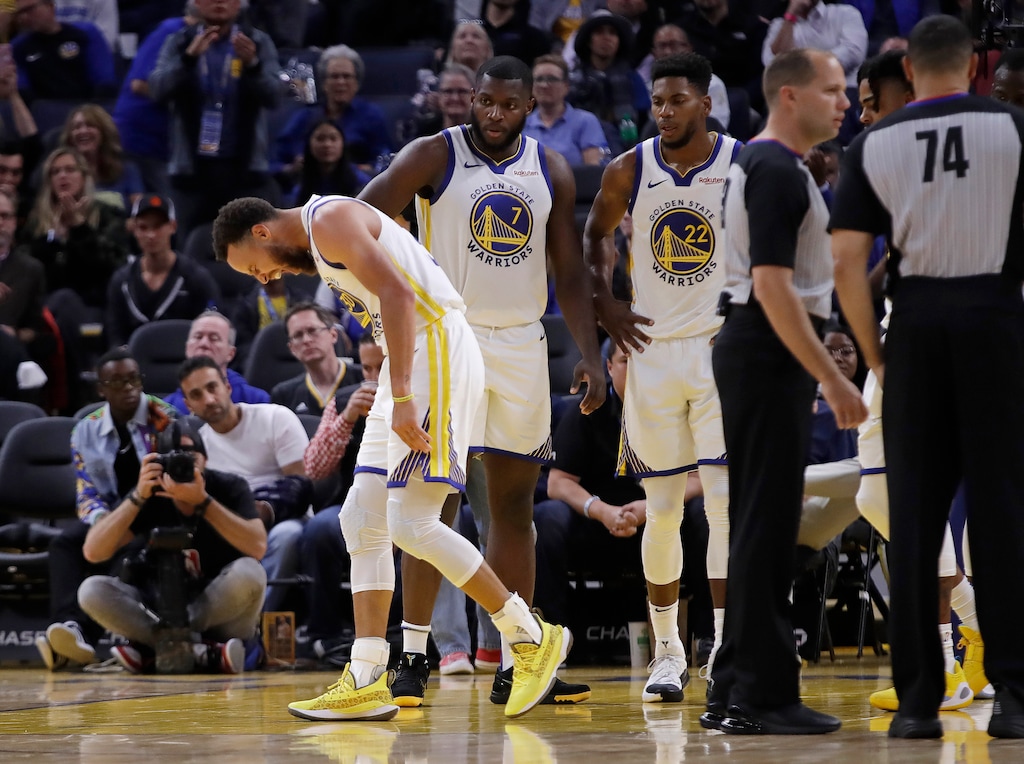 (Ben Margot | AP file photo) Golden State Warriors' Stephen Curry, left, grimaces after Phoenix Suns' Aron Baynes fell onto him during the second half of an NBA basketball game Wednesday, Oct. 30, 2019, in San Francisco. Curry left the game.