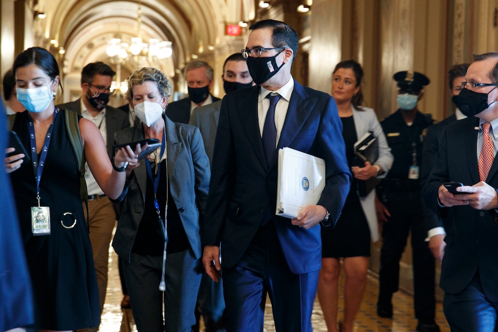 (Jacquelyn Martin | AP photo) Treasury Secretary Steven Mnuchin , center, walks to a Republican luncheon, Tuesday, July 21, 2020, while attending meetings on Capitol Hill in Washington. In the background at center left is White House Chief of Staff Mark Meadows.