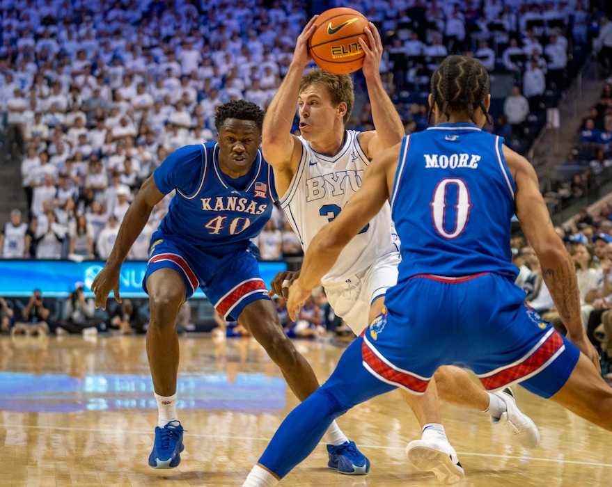 (Rick Egan | The Salt Lake Tribune) Brigham Young Cougars guard Dallin Hall (30) goes to the hoop, as Kansas Jayhawks forward Flory Bidunga (40) and Kansas Jayhawks guard Shakeel Moore (0) defend, in Big 12 basketball action between the Brigham Young Cougars and the Kansas Jayhawks, at the Marriott Center, in Provo, on Tuesday, Feb 18, 2025.