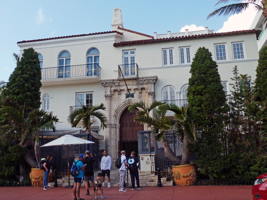 In this Tuesday, Dec. 26, 2017 photo, tourists pose for photographs and read a restaurant menu in front of The Villa Casa Casuarina, a boutique hotel that once was the home of fashion designer Gianni Versace in Miami Beach, Fla. The new season of "American Crime Story" features the murder of Versace, who was fatally shot on his front steps in 1997 by serial killer Andrew Cunanan. (AP Photo/Jennifer Kay)