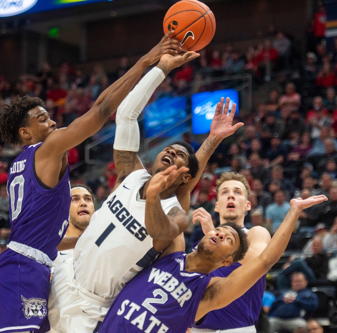 (Rick Egan  |  The Salt Lake Tribune)   Utah State Aggies guard Tauriawn Knight (1) shoots as Weber State Wildcats guard Jerrick Harding (10) and Weber State Wildcats guard Ricky Nelson (2) defend,  in basketball action in the Beehive Classic, between against the Utah State Aggies and Weber State Wildcats, a the Vivint Smart Home Arena, Saturday December 8, 2018. 