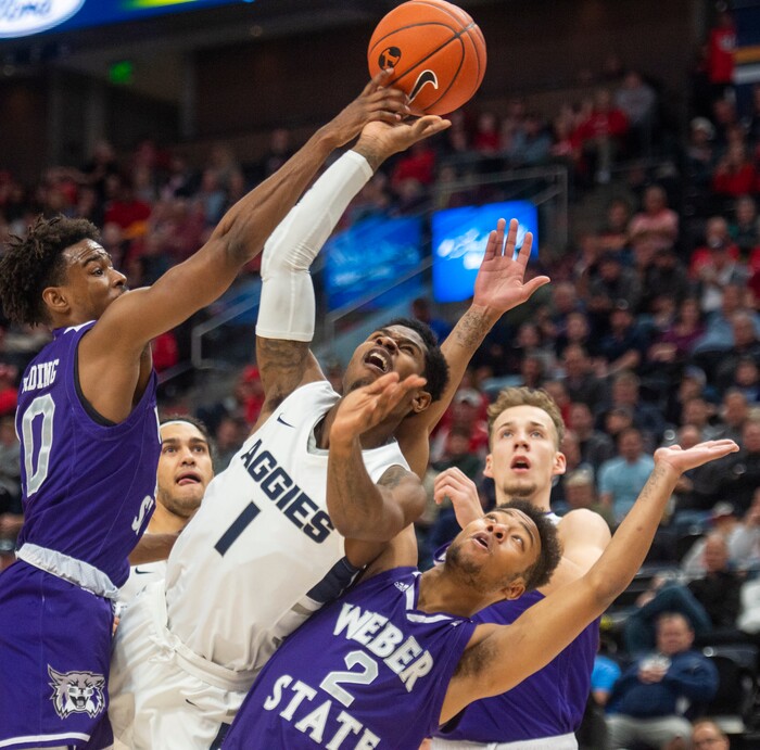 (Rick Egan  |  The Salt Lake Tribune)   Utah State Aggies guard Tauriawn Knight (1) shoots as Weber State Wildcats guard Jerrick Harding (10) and Weber State Wildcats guard Ricky Nelson (2) defend,  in basketball action in the Beehive Classic, between against the Utah State Aggies and Weber State Wildcats, a the Vivint Smart Home Arena, Saturday December 8, 2018.

 