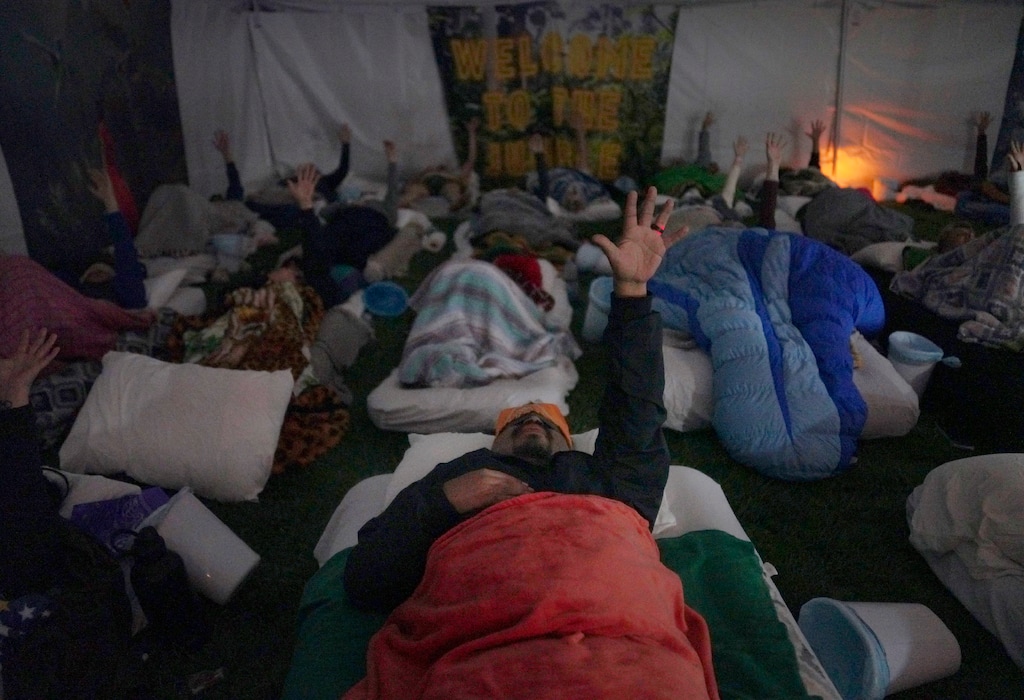 (Jessie Wardarski | AP) Lorenzo Gonzales, center, and other retreat participants reach their hands to the sky during a breathwork ceremony on Saturday, Oct. 15, 2022, in Hildale. The session was a part of a three-night ayahuasca ceremony hosted by Hummingbird Church.