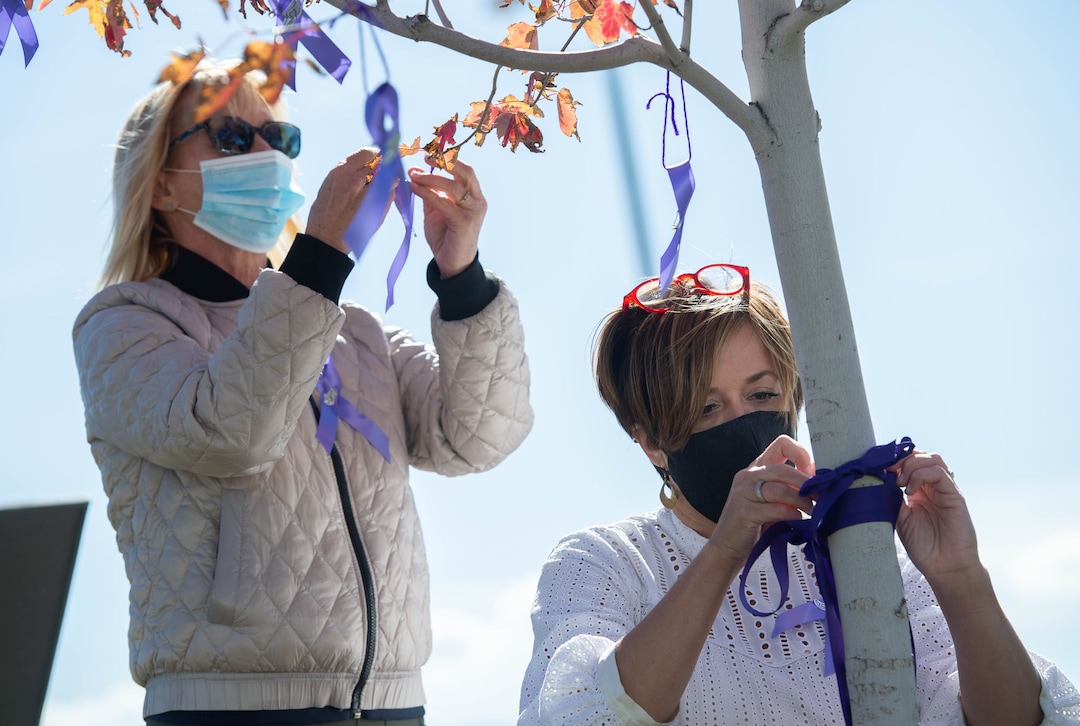 (Francisco Kjolseth  |  The Salt Lake Tribune) Robyn Kremer, left, and Aimee Stone, attach purple ribbons to a tree that was planted in honor of University of Utah student and track athlete Lauren McCluskey on the two-year anniversary of her murder on Thursday, Oct. 22, 2020. Planted next to the track where she used to compete, friends, family and fellow student athletes gathered for a memorial walk to remember her.