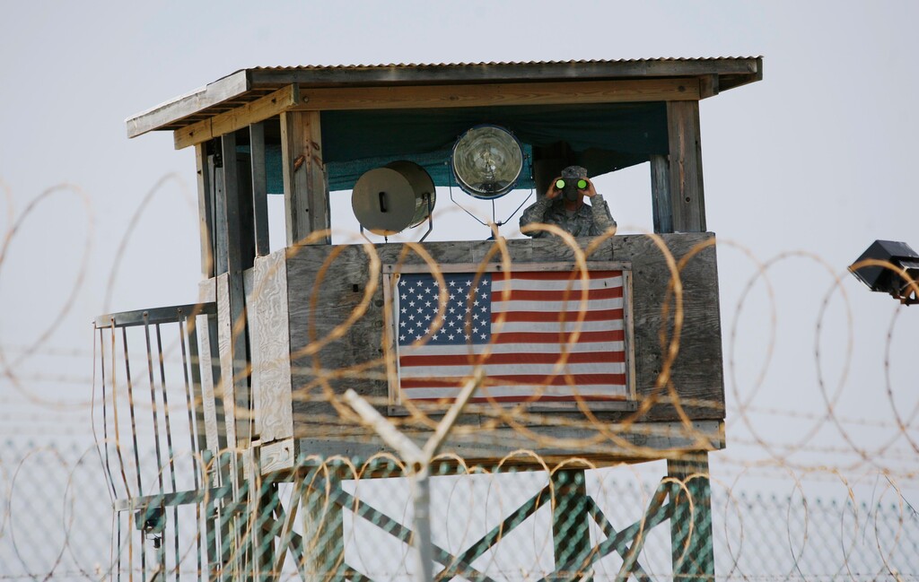 (Rodrigo Abd | Associated Press file photo)  In this May 13, 2008 file photo reviewed by the U.S. military, a U.S. Army soldier looks through binoculars while standing on a guard tower at Camp 4 in the Guantanamo Bay US Naval Base in Cuba.