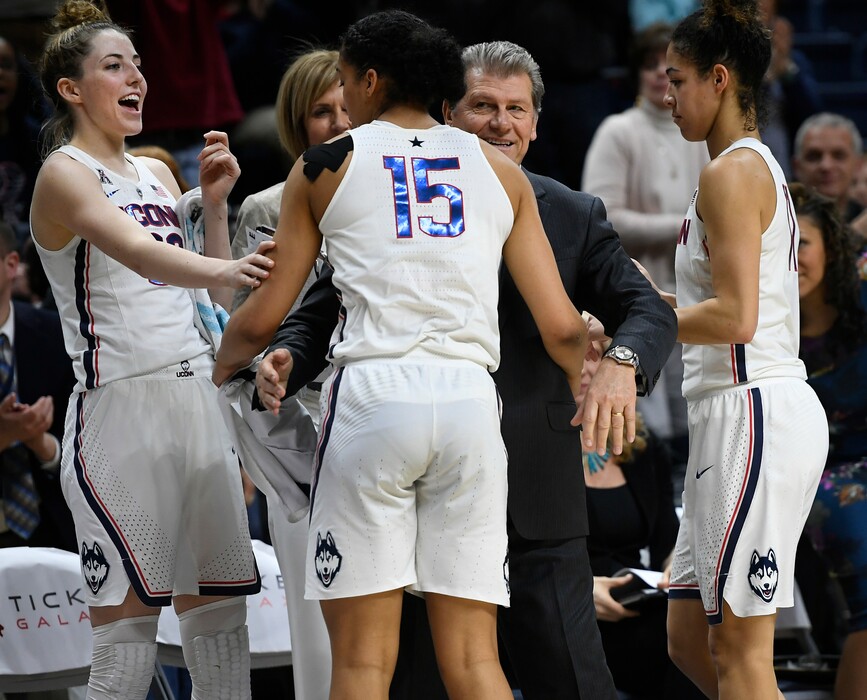 FILE - In this Feb. 26, 2018, file photo, Connecticut head coach Geno Auriemma, center, and player Katie Lou Samuelson, left, smile as seniors Gabby Williams, center, and Kia Nurse leave play for the final time in regular season play during the second half an NCAA college basketball game against South Florida, in Storrs, Conn. UConn finishes No. 1 in The Associated Press women's basketball poll for the fifth straight year. The Huskies (32-0) enter the NCAA Tournament as the lone unbeaten team and went wire-to-wire as the unanimous top team. They received all 32 votes from the national media panel Monday, March 12, 2018. (AP Photo/Jessica Hill, File)