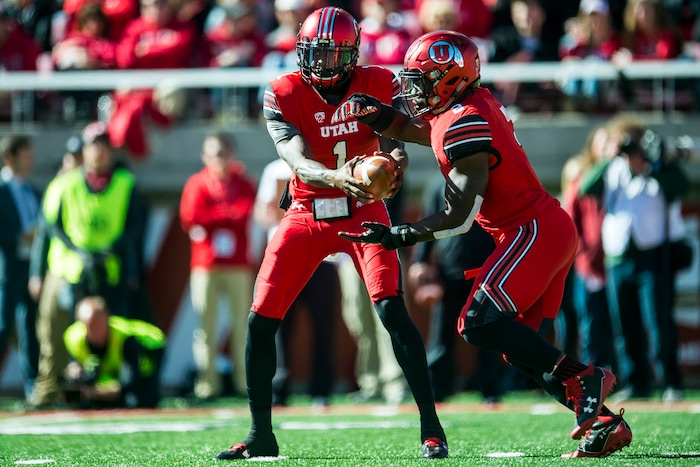 (Chris Detrick  |  The Salt Lake Tribune)  Utah Utes quarterback Tyler Huntley (1) hands off to Utah Utes running back Zack Moss (2) during the game at Rice-Eccles Stadium Saturday, October 21, 2017. 