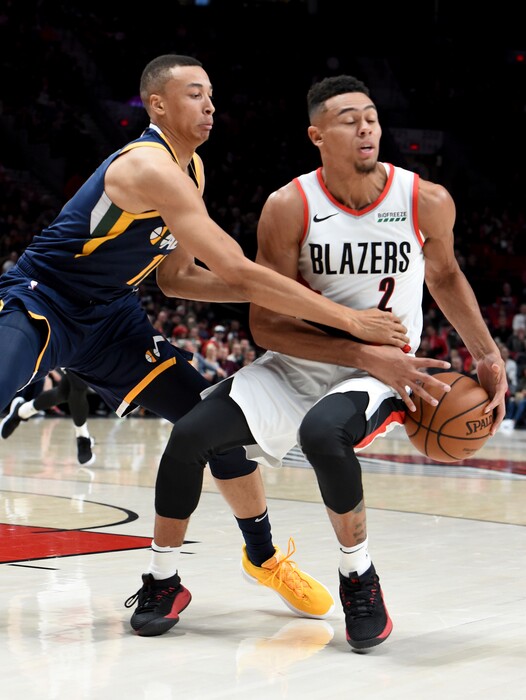 Utah Jazz guard Dante Exum reaches in on Portland Trail Blazers guard Wade Baldwin IV during the first half of an NBA basketball game in Portland, Ore., Sunday, Oct. 7, 2018. (AP Photo/Steve Dykes)