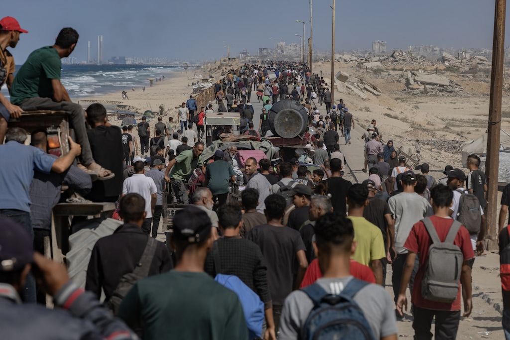 Palestinians return north towards Gaza City along the coastal road near the Nuseirat refugee camp in central Gaza on Friday, Oct. 10, 2025. (Saher Alghorra/The New York Times)