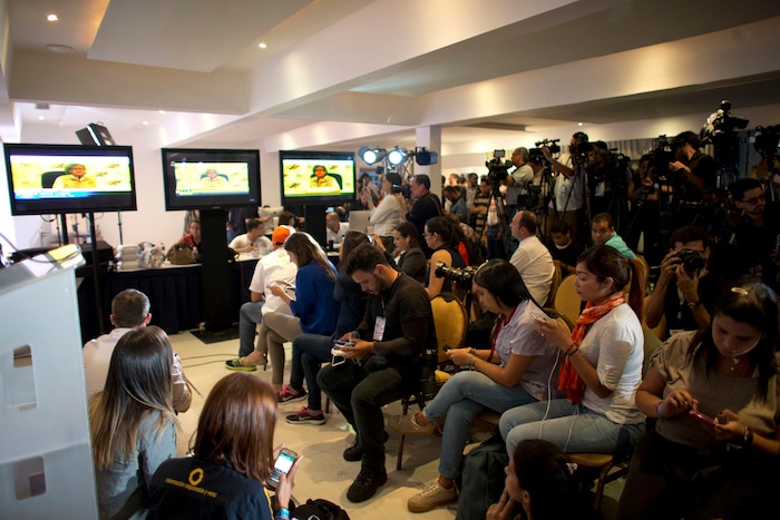 Media members listen to the President of Venezuelan National Electoral Council Tibisay Lucena announcing that the candidates for the ruling socialist party have won a majority of the 23 governors' offices up for grabs in regional elections at opposition headquarters in Caracas, Venezuela, Sunday, Oct 15, 2017. Pro-government electoral council president Tibisay Lucena says opposition candidates won just five of 22 races where the results are considered irreversible. (AP Photo/Ariana Cubillos)