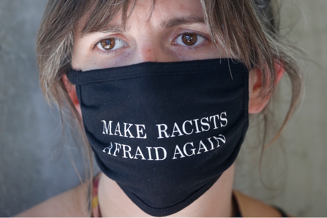 A protester watches a rally Sunday, Aug. 2, 2020, in Cottonwood Heights, Utah. The protest was a "March for Justice" focused largely around Zane James, fatally shot police in Cottonwood Heights in 2018. (AP Photo/Rick Bowmer)