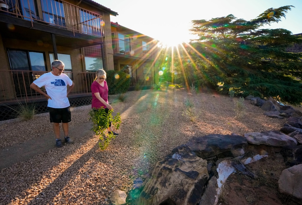 (Francisco Kjolseth  |  The Salt Lake Tribune) Aubrey Quick, the treasurer for the Gardens South Condominiums homeowners association in St. George, is joined by her husband Dale Hawkins, as they tour a project to remove grass in common areas in their community on Tuesday, June 11, 2024. Thus far, the condominium complex has replaced 5,000 square feet of grass. 