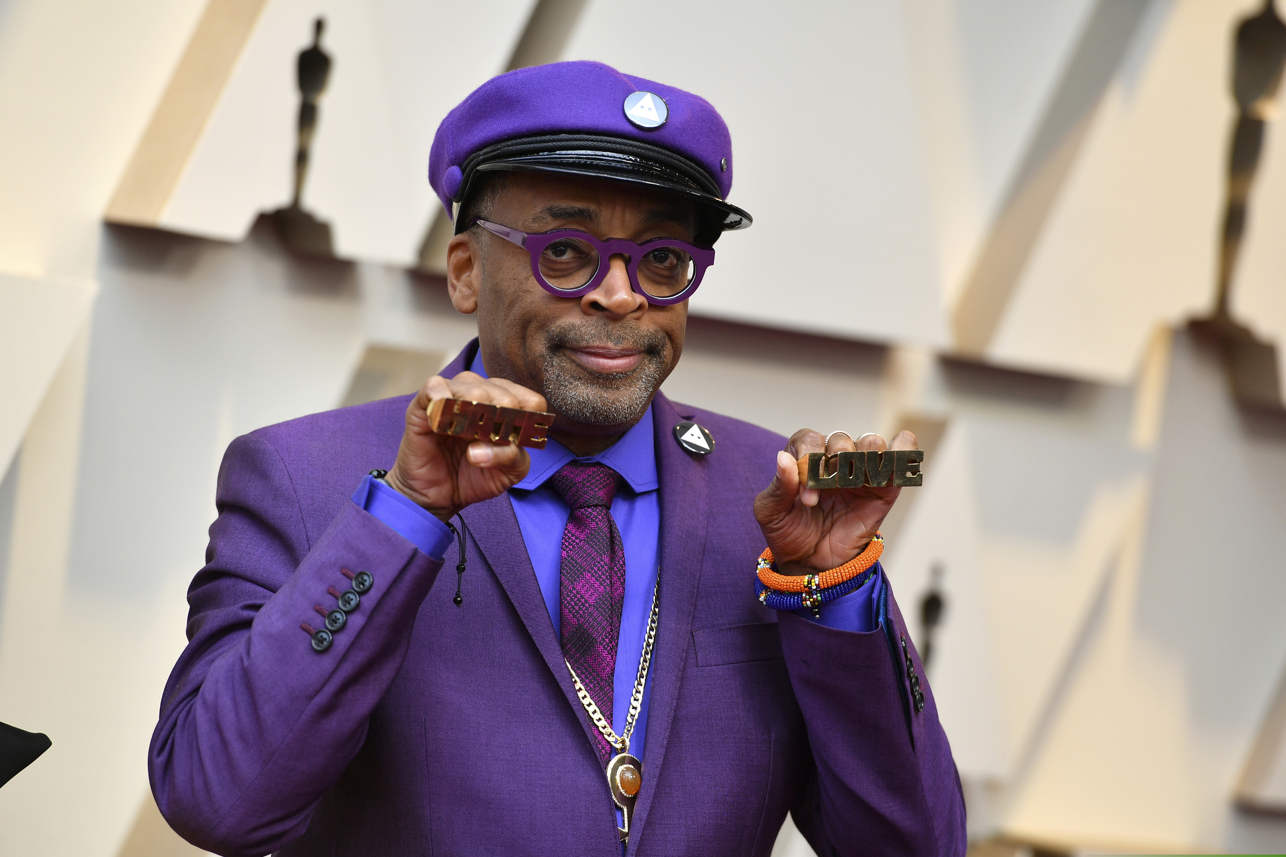 Spike Lee holds up brass knuckles reading "hate" and "love" from his iconic film "Do The Right Thing" as he arrives at the Oscars on Sunday, Feb. 24, 2019, at the Dolby Theatre in Los Angeles. (Photo by Jordan Strauss/Invision/AP)