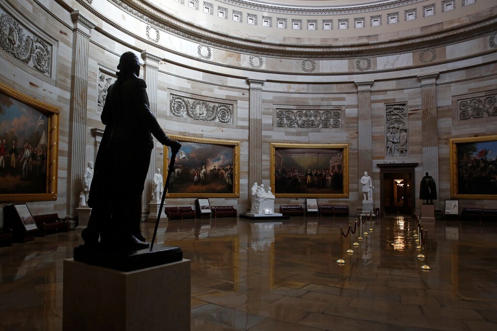 (Patrick Semansky | AP file photo)  In this April 9 photo, a statue of President George Washington looks over an empty Capitol Rotunda on Capitol Hill in Washington.