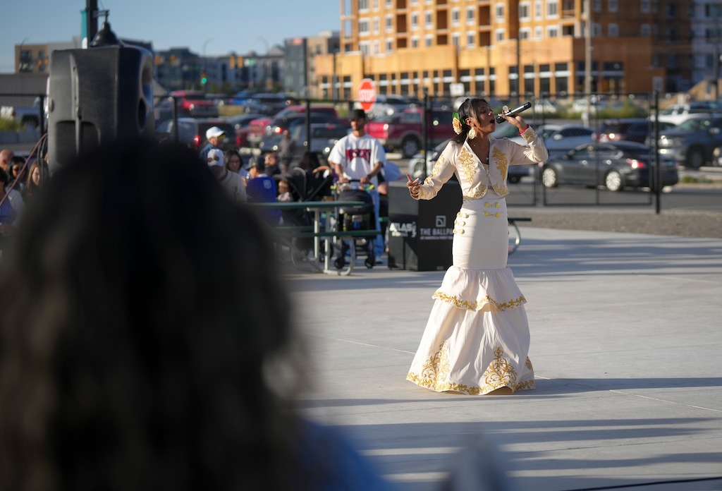 (Bethany Baker  |  The Salt Lake Tribune) Stacey Loya sings during the third annual Béisbol en Salt Lake event on Saturday, Sept. 26, 2026. It's the second year it's been held at The Ballpark at America First Square.