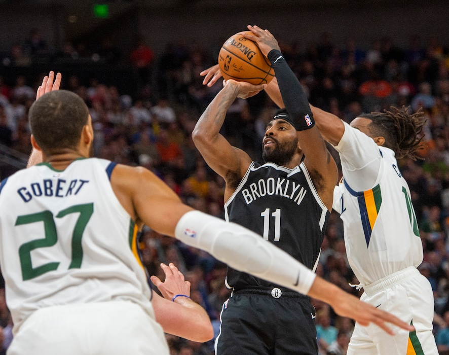 (Rick Egan  |  The Salt Lake Tribune)        Brooklyn Nets guard Kyrie Irving (11) shoots as Utah Jazz center Rudy Gobert (27) and Utah Jazz guard Mike Conley (10) defend, in NBA basketball action between the Utah Jazz and the Brooklyn Nets in Salt Lake City, Tuesday, Nov 12, 2019.