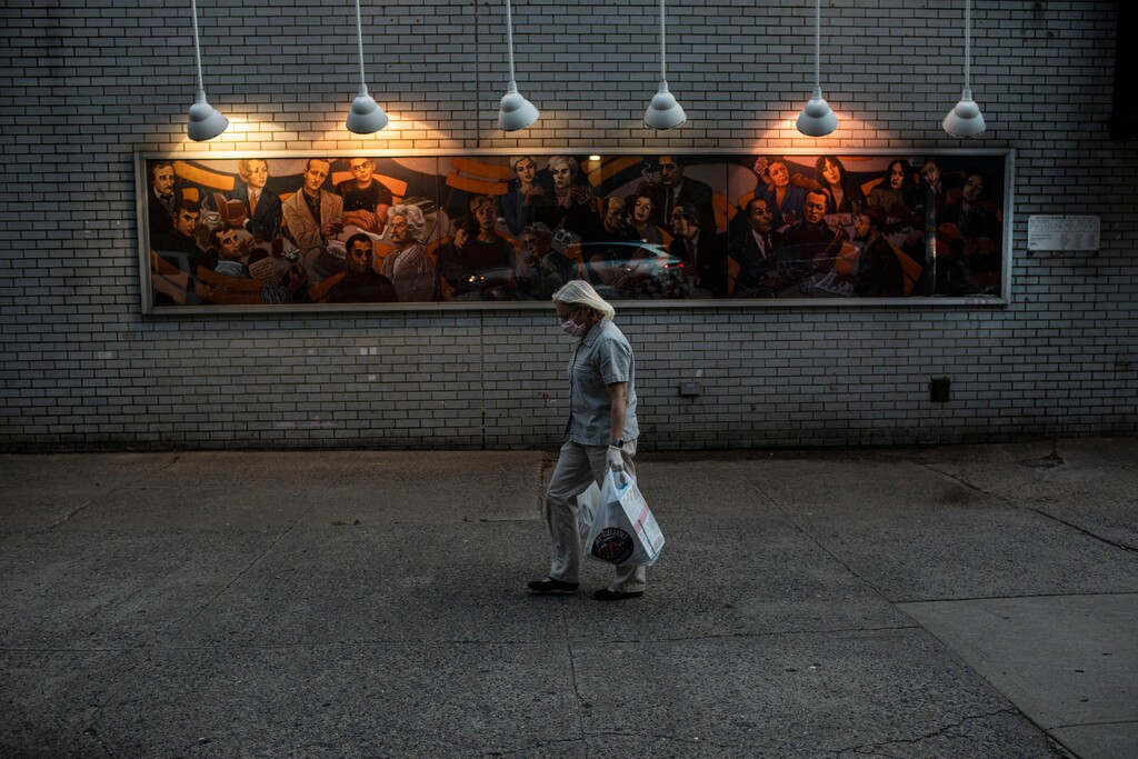(Robert Bumsted | AP file photo) A woman carries shopping bags as she leaves a grocery store in New York on June 10, 2020.