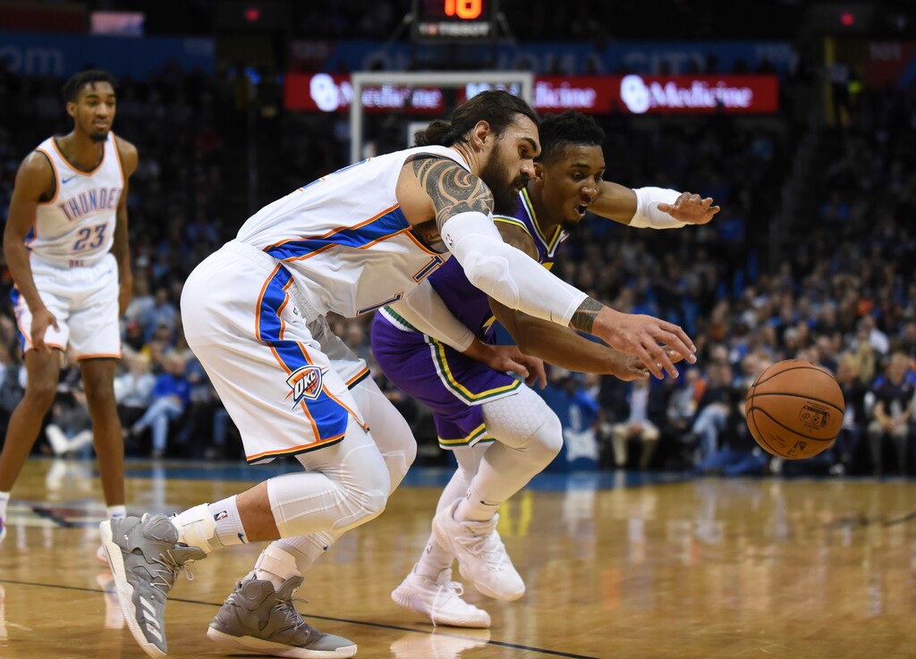Oklahoma City Thunder center Steven Adams, front left, fights Utah Jazz guard Donovan Mitchell, right, for control of the ball in the first half of an NBA basketball game in Oklahoma City, Monday, Dec. 10, 2018. (AP Photo/Kyle Phillips)