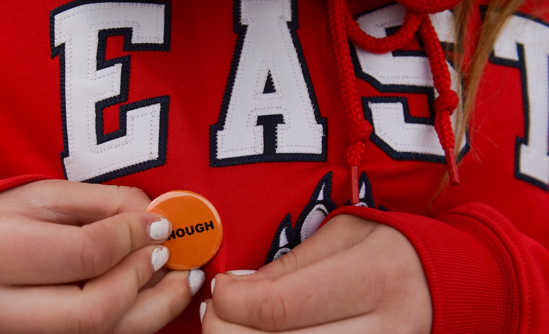 (Leah Hogsten  |  The Salt Lake Tribune)  East High School student Taylor Shelton fastens an #Enough pin to her sweatshirt. Exactly one month after 17 people were killed at Marjory Stoneman Douglas High School in Parkland, survivors of the massacre joined tens of thousands of students across the United States by walking out of school,  Wednesday, March 14, 2018. 