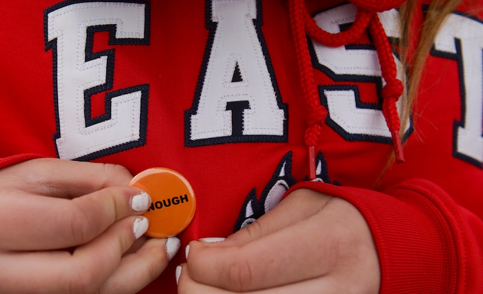 (Leah Hogsten  |  The Salt Lake Tribune)  East High School student Taylor Shelton fastens an #Enough pin to her sweatshirt. Exactly one month after 17 people were killed at Marjory Stoneman Douglas High School in Parkland, survivors of the massacre joined tens of thousands of students across the United States by walking out of school,  Wednesday, March 14, 2018. 