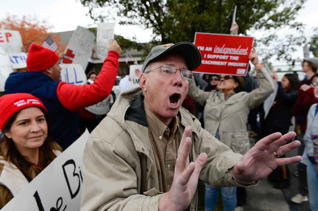 (Francisco Kjolseth | The Salt Lake Tribune) Two competing rallies spar near Rep. Ben McAdams' office in West Jordan, one seeking to support McAdams and one to criticize him for supporting the impeachment inquiry of President Donald Trump on Wednesday, Oct. 9, 2019, as they try to block one another's signs during a brief moment of confrontation.